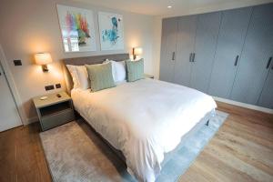 una camera da letto con un grande letto bianco con due lampade di SoHot Stays Harbourside Suite 2nd Floor Sleeps 4 a Kent