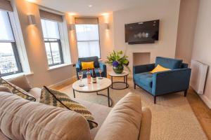 un soggiorno con divano, sedie e TV di SoHot Stays Harbourside Suite 2nd Floor Sleeps 4 a Kent