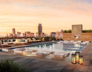 a pool with lounge chairs and a city skyline in the background at 2BD Condo-Rainey St-Best views-RT Pool in Austin