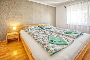 um quarto com uma cama com duas toalhas verdes em Vila Ochutnej Pálavu - apartmán Riesling em Pavlov