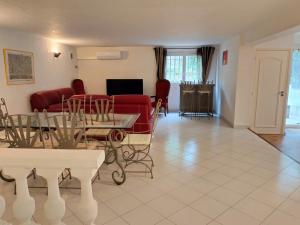 a living room with a red couch and a table at Location Rez de maison dans quartier charmant in Saint-Raphaël