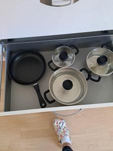 a stove top with four pots and pans on it at Ferienwohnung Rosengarten in Ballenstedt