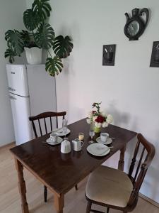 a wooden table with two chairs and a table with flowers on it at Ferienwohnung Rosengarten in Ballenstedt +17 photos