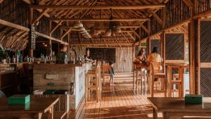 un restaurante con bar y gente sentada en las mesas en Dos Aguas Lodge, en Rincón