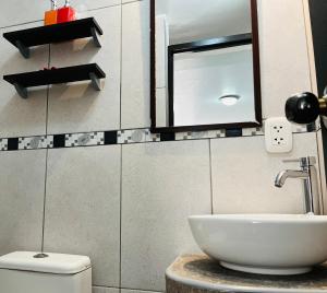 un bagno con lavandino, WC e specchio di Sambleña a Cuzco