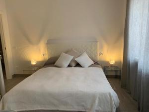 a bedroom with a white bed with two lamps at Domus Dotta New in Bologna