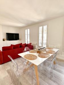 a living room with a red couch and a table at Logement entier 75 m2 in Boulogne-Billancourt