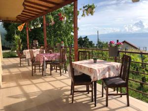 ein Restaurant mit Tischen und Stühlen auf einer Terrasse in der Unterkunft RISTESKI GUEST HOUSE in Ohrid