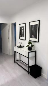 um quarto branco com uma mesa com uma planta em Neptun guest house em Queluz