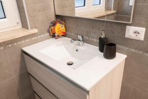 a bathroom with a white sink and a mirror at Casa Larry in Marino