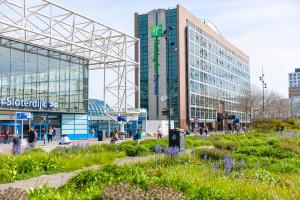 un gruppo di edifici in una città con fiori di Holiday Inn Express Amsterdam - Sloterdijk Station, an IHG Hotel ad Amsterdam