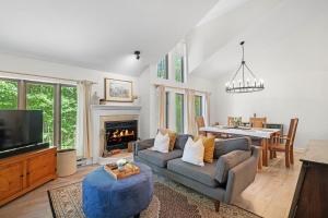 a living room with a couch and a tv at Le Champetre Tremblant 2bdrs Condo W Fireplace in Mont-Tremblant