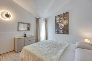 Un dormitorio blanco con una cama y un espejo. en Sara Luxury in City Center, en Poreč