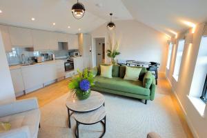 a living room with a green couch and a table at SoHot Stays The Penthouse Suite - Harbour Views - Sleeps 4 in Kent