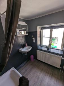 een badkamer met een bad, een wastafel en een raam bij Flensburg Zentrum 10 HH 1OG ML in Flensburg