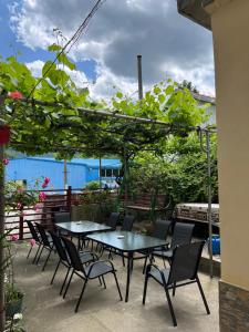 a patio with tables and chairs under a pergola at Casa Dina in Băile Herculane