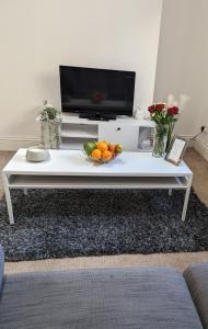 a white coffee table with a bowl of fruit on it at 1 bedroom flat in Gravesend in Kent