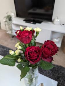 a vase filled with red roses on a table at 1 bedroom flat in Gravesend in Kent