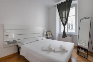 a bedroom with a white bed with two towels on it at Charme Bukowski, a Trieste centro con parcheggio in Trieste