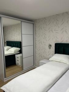 1 Schlafzimmer mit 2 Betten und einem großen Spiegel in der Unterkunft Apartman Kosuta Lux in Tjentište