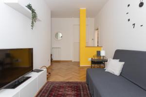 ein Wohnzimmer mit einem Sofa und einem Flachbild-TV in der Unterkunft Charme Bukowski, a Trieste centro con parcheggio in Triest