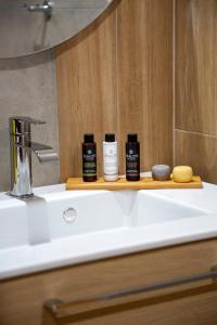 a bathroom sink with two bottles of hair products on it at The Frogs_Guest House in Athens
