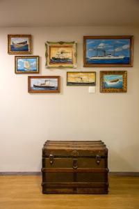 an old suitcase sitting in front of a wall with paintings at The Frogs_Guest House in Athens