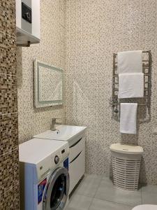 a bathroom with a washing machine and a sink at ALION HOTEL Бугаз Перша Лінія in Zatoka
