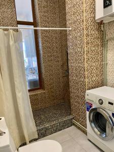 a bathroom with a shower with a washing machine at ALION HOTEL Бугаз Перша Лінія in Zatoka