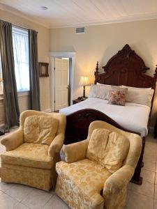 um quarto com uma cama grande e 2 cadeiras em The Inn at Cedar Grove em Vicksburg