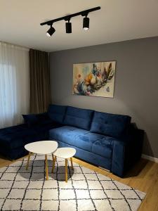 a living room with a blue couch and a table at Apartman Kosuta Lux in Tjentište