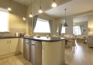 a kitchen and living room with a sink and a dishwasher at Wing Cottage in Orford