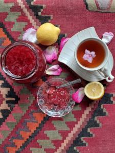 a cup of tea and a bowl of liquid and a lemon at Guest House Ruh Achari in Sheki