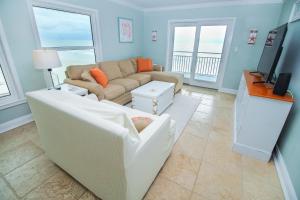 a living room with a couch and a tv at Sea Coast Gardens II 401 in New Smyrna Beach