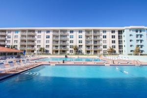 une grande piscine en face d'un grand immeuble dans l'établissement Sea Coast Gardens II 401, à New Smyrna Beach