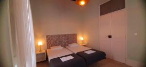 ファロにあるHostel A Casa da Árvoreの小さなベッドルーム(ベッド2台、ランプ2つ付)