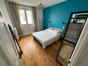 um quarto azul com uma cama e uma escada em Jolie maison ételoise - mer , cœur d etel em Étel