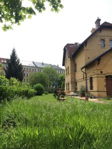 un parque con bancos, un edificio y césped en Alte Bahnstation Leipzig (Appartement TWO & ONE), en Leipzig