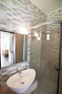 een badkamer met een wastafel en een glazen douche bij Hotel Kanali in Kanali