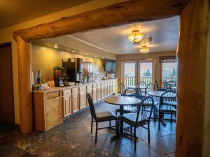 a restaurant with tables and chairs and a kitchen at Mountain Vista Hotel in West Yellowstone