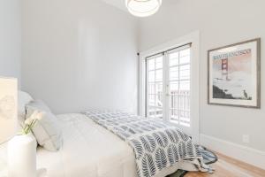 a white bedroom with a bed and a window at STYLISH AND SPACIOUS 2ND Flr 2 BR VICTORIAN HOME in San Francisco