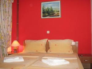 um quarto com uma cama com uma parede vermelha em Villa Ohrid Anastasia em Ohrid
