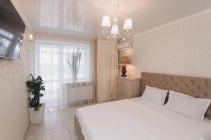 1 dormitorio con cama blanca y ventana en VIP Apartment on Diemiana Korotchienko, en Sumy