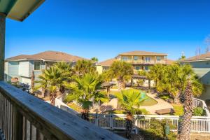 a view from the balcony of a resort with palm trees at After Dune Delight in Port Aransas
