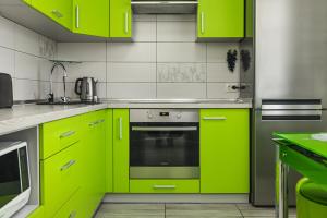 cocina con armarios de color verde lima y horno en VIP Apartment on Diemiana Korotchienko, en Sumy