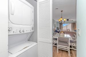 a kitchen and dining room with a white refrigerator at Fully Furnished Ocean View Two Bedroom Condo-Shipwatch Pointe 1- 319G in Myrtle Beach