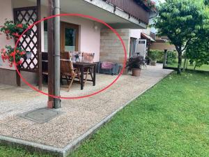 a red circle on a house with a table in a yard at Apartments Kravanja in Bovec