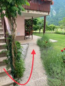 un jardin avec une flèche rouge pointant vers une maison dans l'établissement Apartments Kravanja, à Bovec