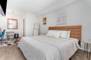 a white bedroom with a large bed and a table at Amazing Downtown Views - 3 Minutes to Downtown! in Cincinnati