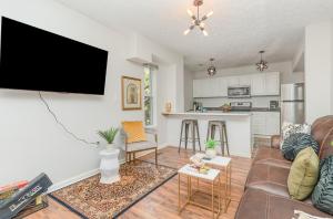 a living room with a couch and a flat screen tv at Amazing Downtown Views - 3 Minutes to Downtown! in Cincinnati